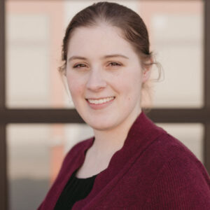 Photo of Sarah Blahovec. She is wearing a dark red sweater with black shirt underneath and her hair pulled back.
