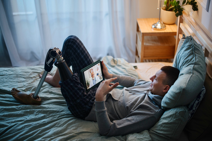 Disabled young man with prosthetic leg having online mental health session