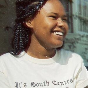 Woman looking off to the side smiling wearing a white t-shirt