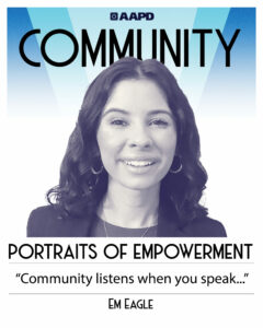 Em’s portrait of empowerment graphic has a black and white image of Em in front of a blue background with the word “Community” at the top. Em is a light tan-skinned woman with shoulder-length dark hair. She is wearing a black blazer, shirt, and necklace with hoop earrings. Her quote reads “Community listens when you speak…”
