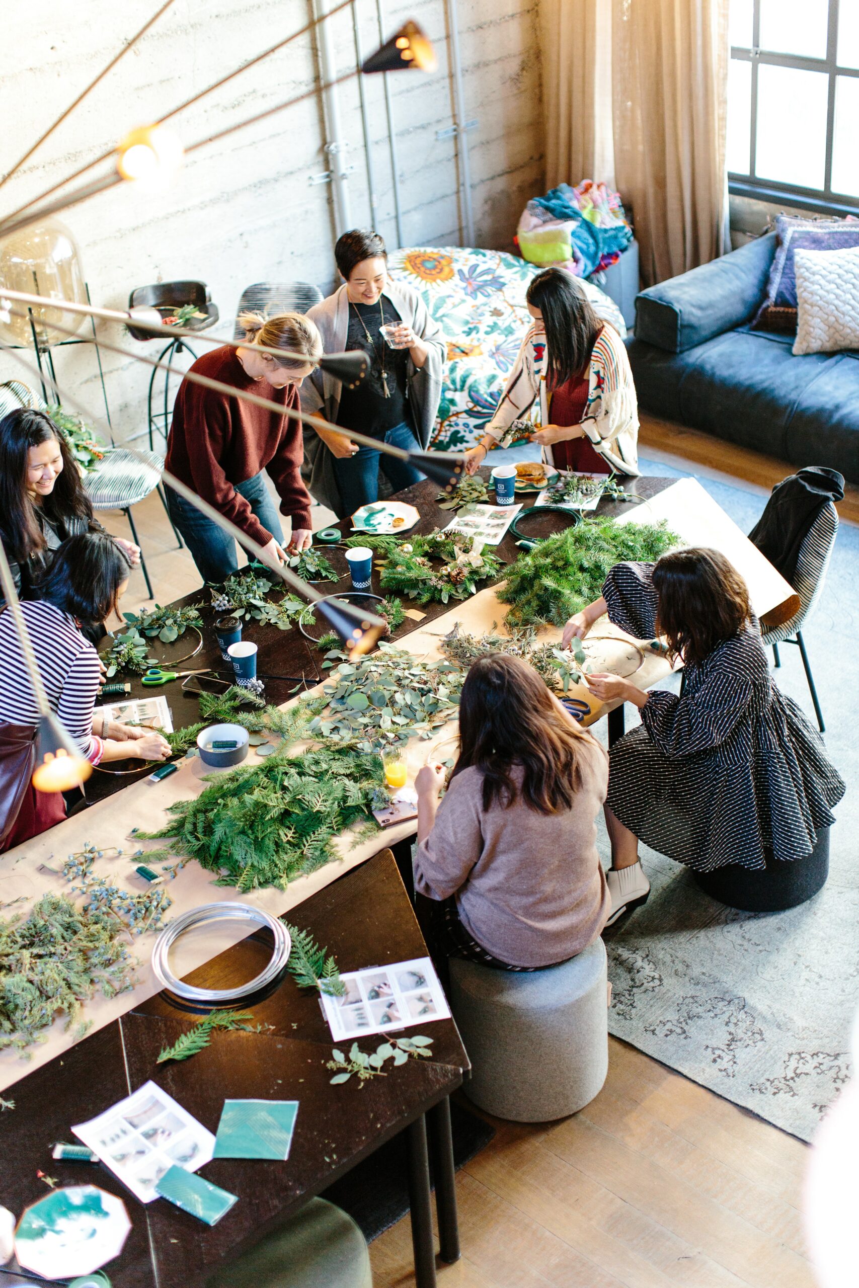 Group of people sitting at a table looking at plants