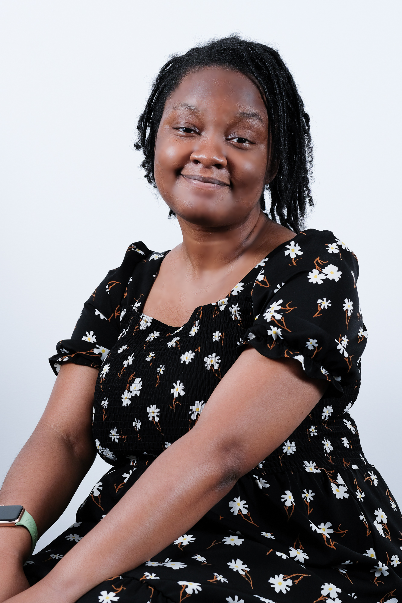 Headshot of Jada Thompson, a black person wearing a black dress with flowers.