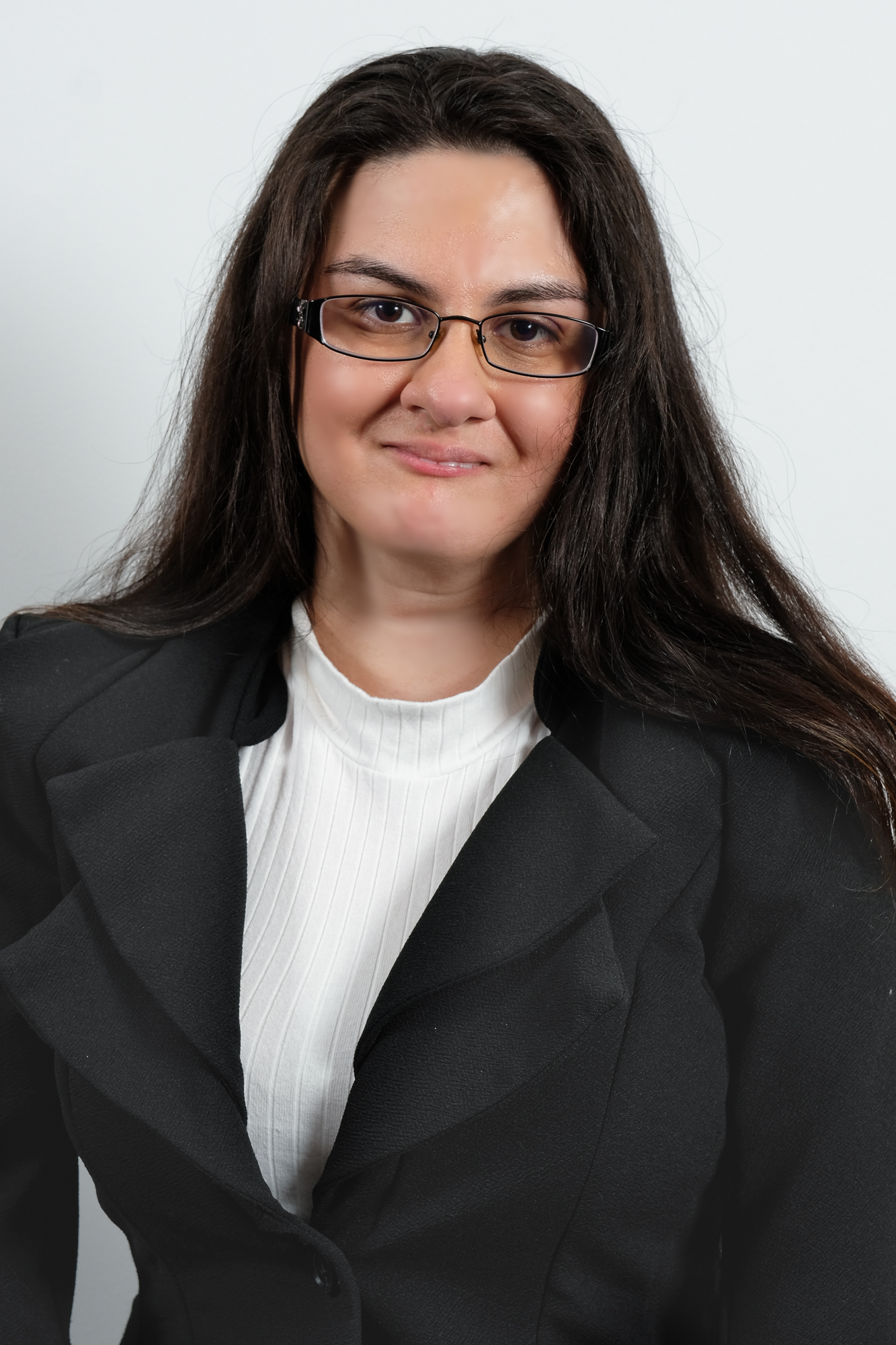 Headshot of Jessica Lopez, a young woman with long, straight brown hair and glasses wearing a white top and black suit jacket
