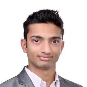 Headshot of Rudraasksh Karthick Bhuvaneswari, a south asian man with short black hair, wearing a white button up and grey suit jacket.