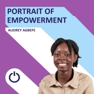 Promotional graphic featuring a young woman with a joyful expression. The background is divided diagonally with purple on the top and a lighter shade below, overlaid with the phrase 'PORTRAIT OF EMPOWERMENT' in white bold text. Below the phrase, the name 'AUDREY AGBEFE' is displayed. The woman is wearing a light brown shirt and has short black hair. In the bottom center, there is a power icon symbol.