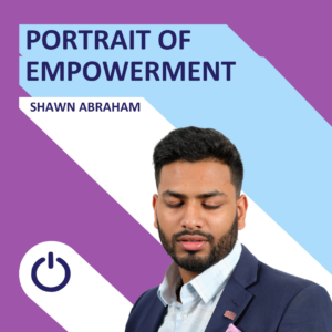 Promotional graphic with a young man named Shawn Abraham. The design features a split background with a diagonal line separating purple on the top and light blue on the bottom. The phrase 'PORTRAIT OF EMPOWERMENT' is displayed prominently at the top in bold white text. Below it is the name 'SHAWN ABRAHAM'. The man has a short beard and hair, and is dressed in a professional blue suit with a checkered shirt. A power icon symbol is located at the bottom center of the graphic.