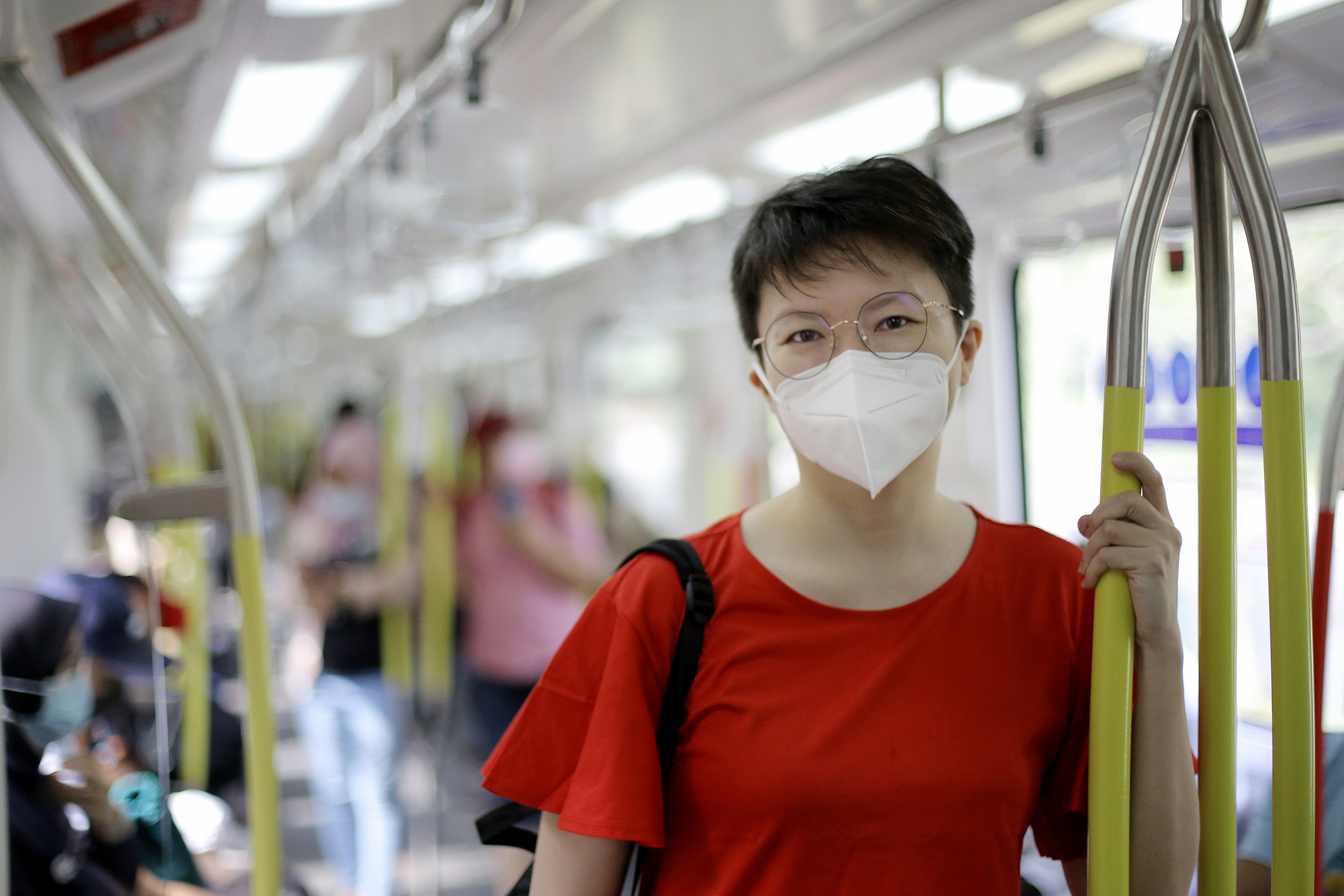 An Asian woman is in on a train.