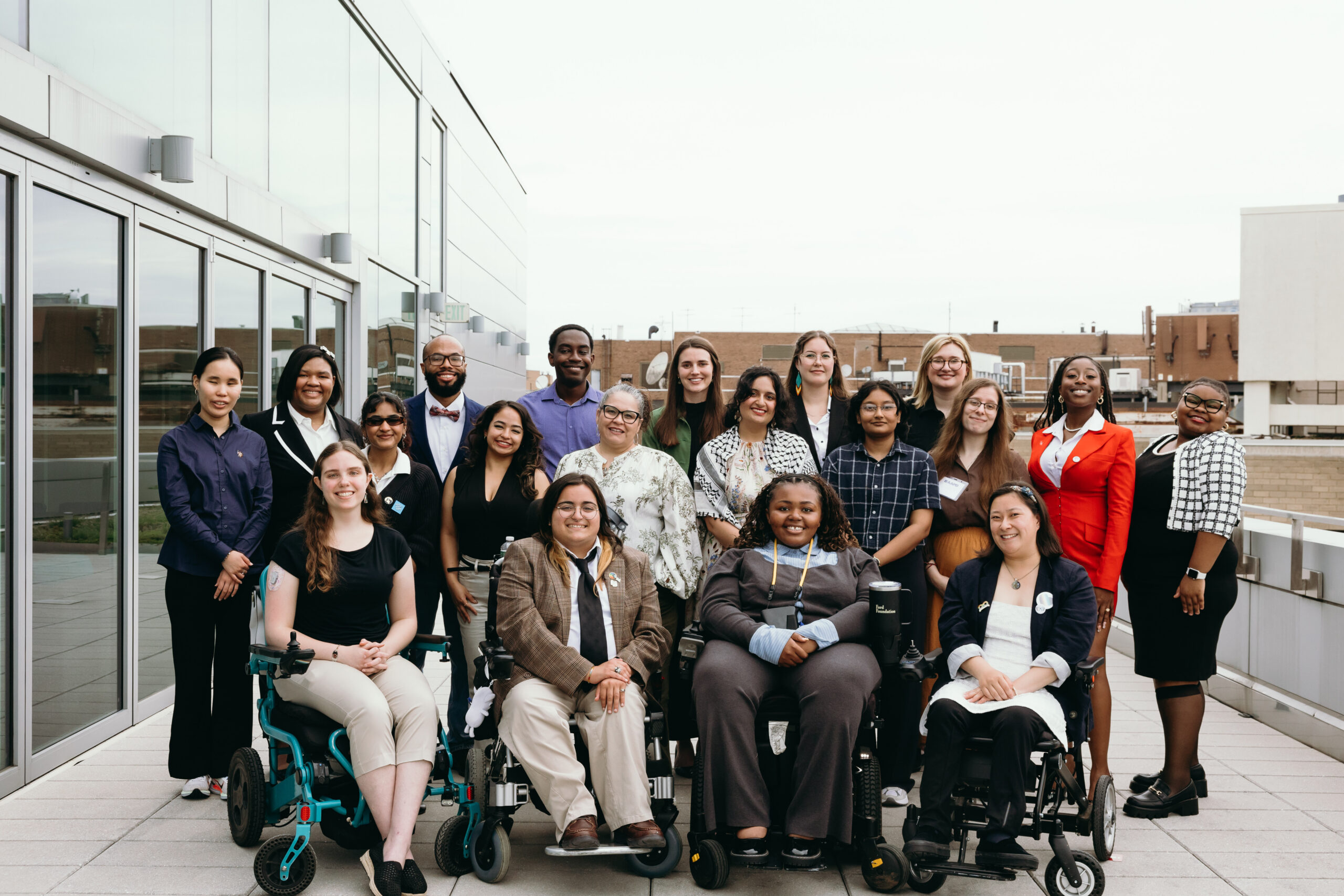 A group of AAPD interns and staff are gathered outside.The group is a diversity of races, genders and disabilities.